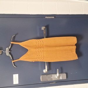 A crotchet knit dress in a tan, orange color.